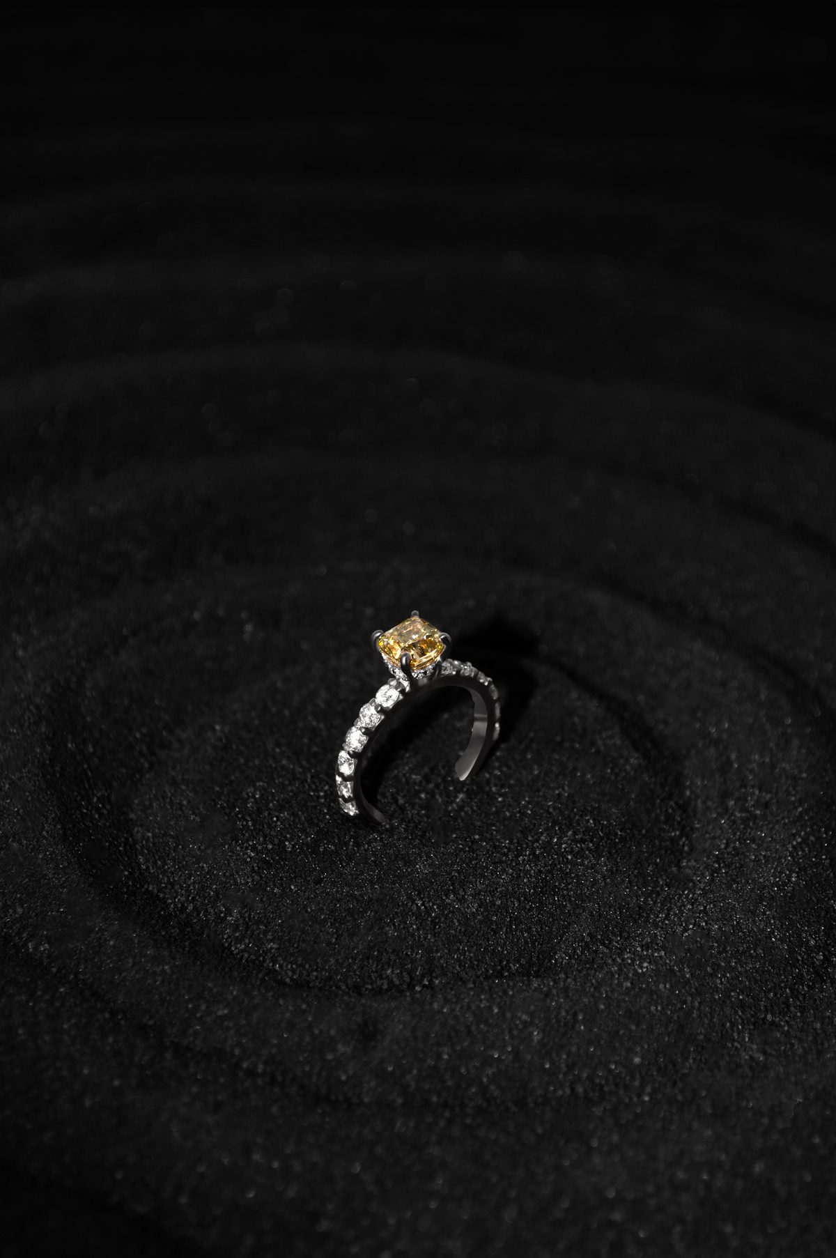 Anillo YS.06 solitario con diamante amarillo de 1.5 quilates y banda de diamantes blancos en oro blanco 18k, sobre arena negra